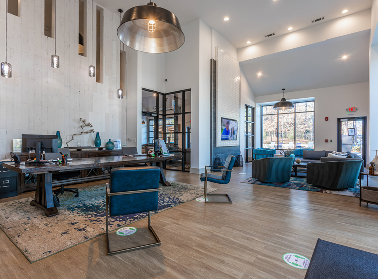 Clubhouse, couches, table, hardwood floors, hanging light fixtures, and window